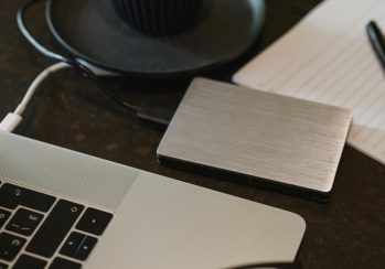 Free Closeup of an external hard drive connected to a laptop with a USB cable on a desk. Stock Photo